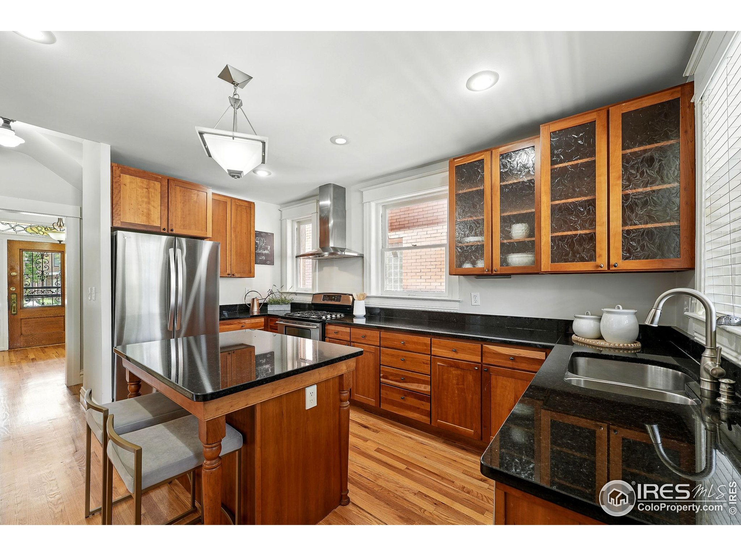 1582 Steele Street Denver, CO 80206 - Photo 19 of 48 a kitchen with stainless steel appliances granite countertop a stove and refrigerator