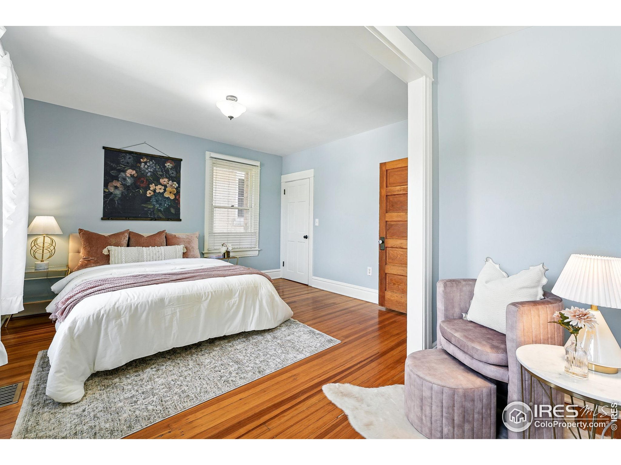 1582 Steele Street Denver, CO 80206 - Photo 24 of 48 a bedroom with a bed and wooden floor
