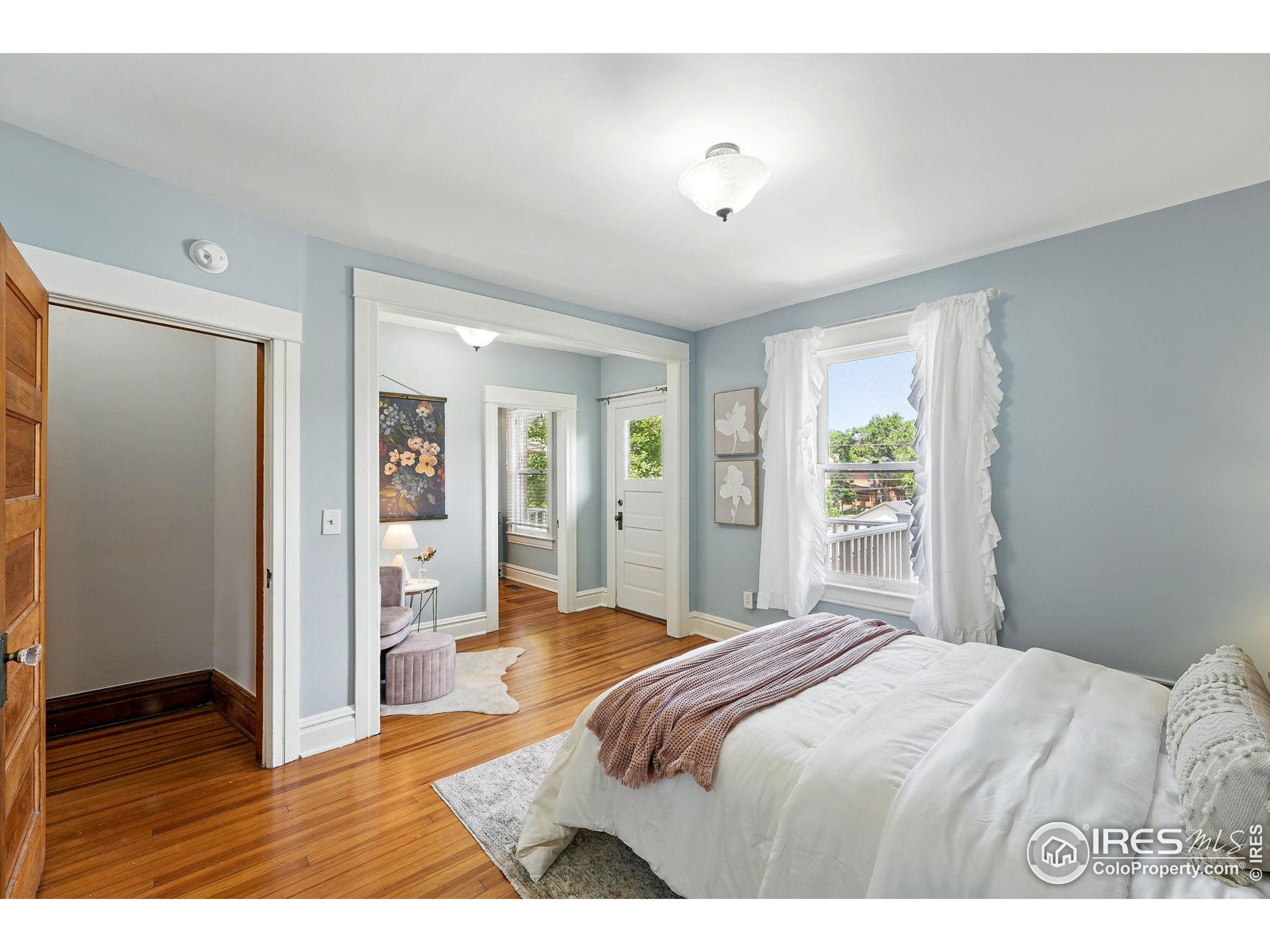 1582 Steele Street Denver, CO 80206 - Photo 25 of 48 a bedroom with a bed and wooden floor