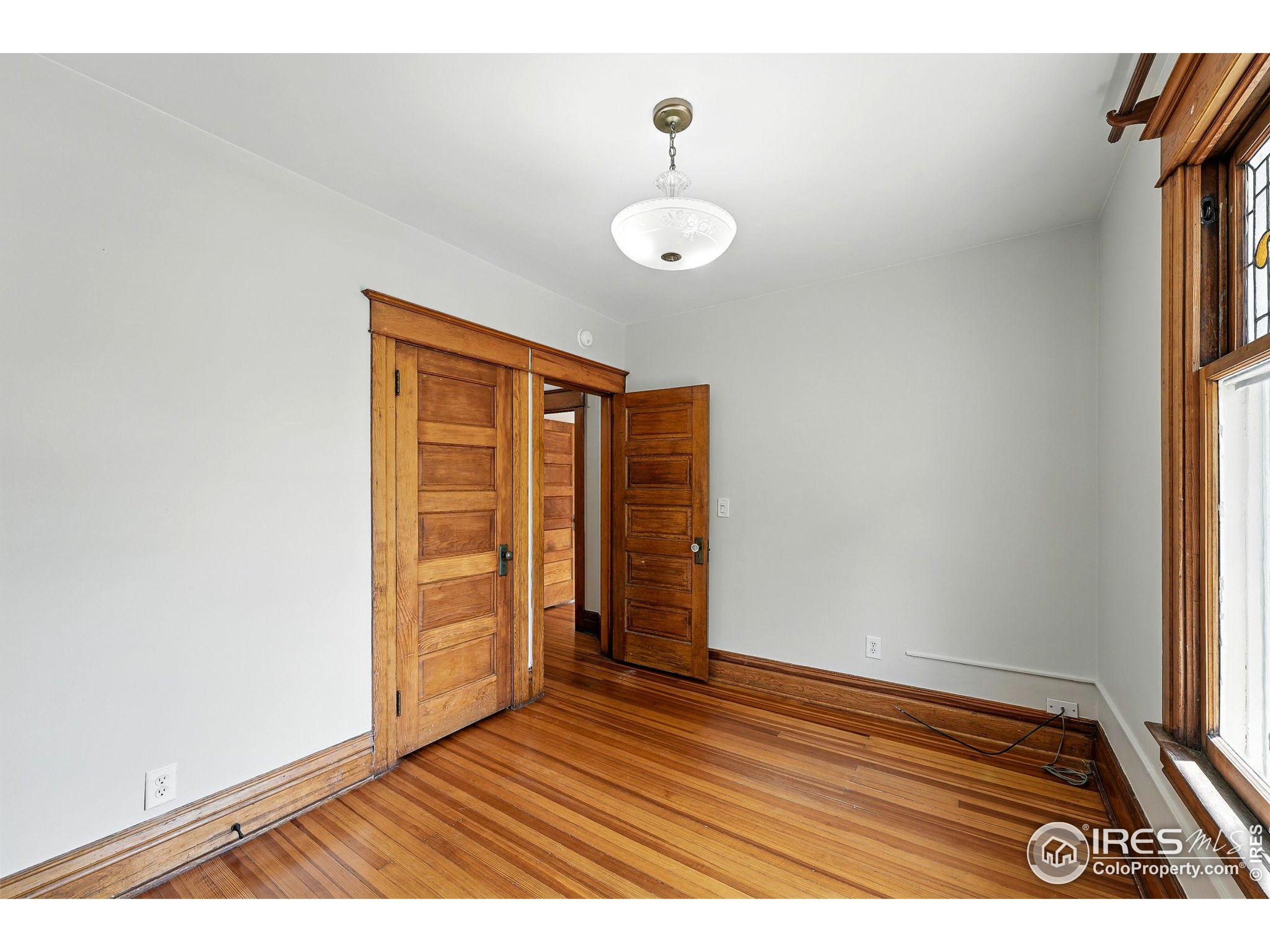 1582 Steele Street Denver, CO 80206 - Photo 31 of 48 an empty room with wooden floor and windows
