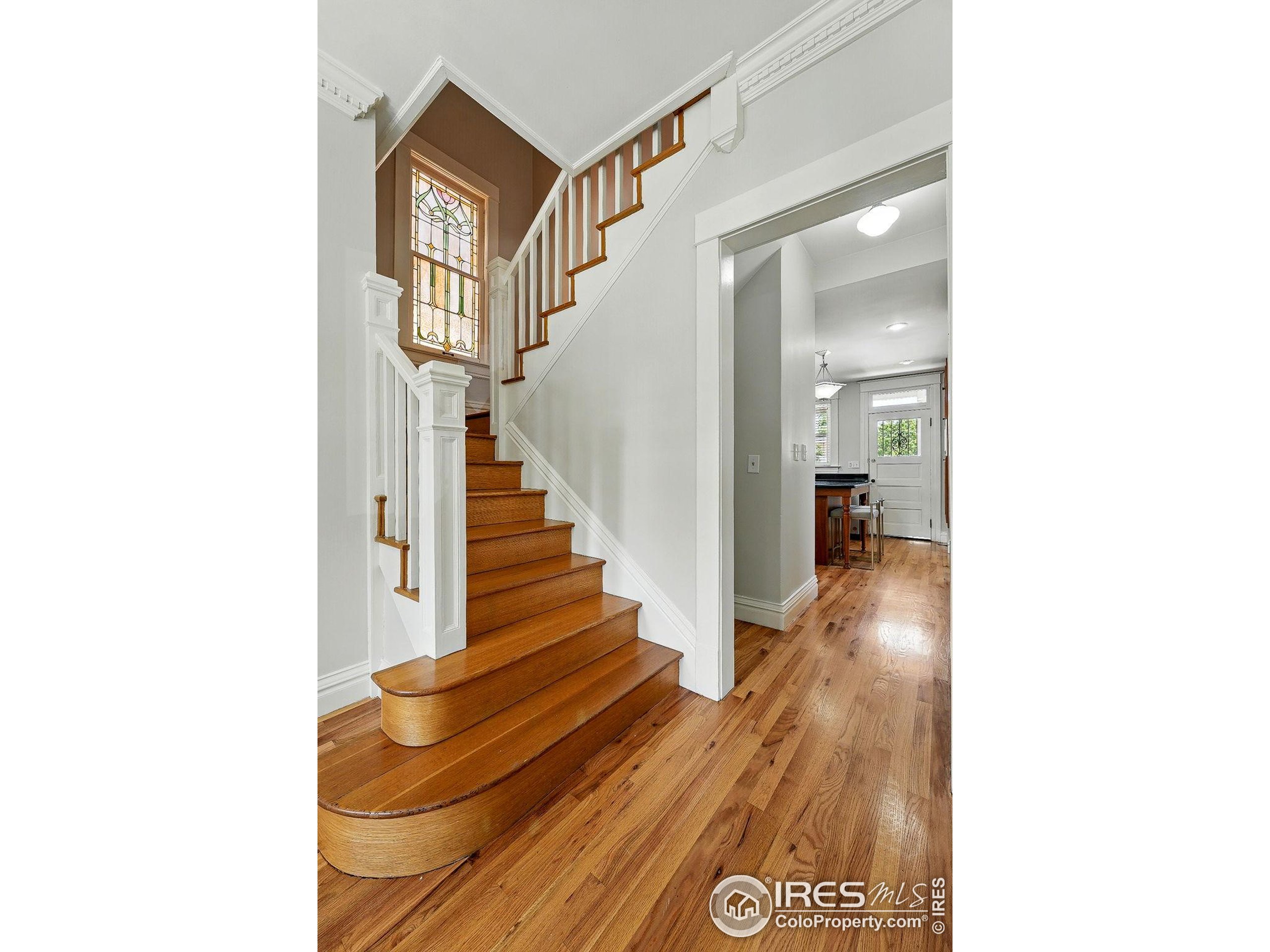 1582 Steele Street Denver, CO 80206 - Photo 6 of 48 a view of a hallway with wooden floor and stairs