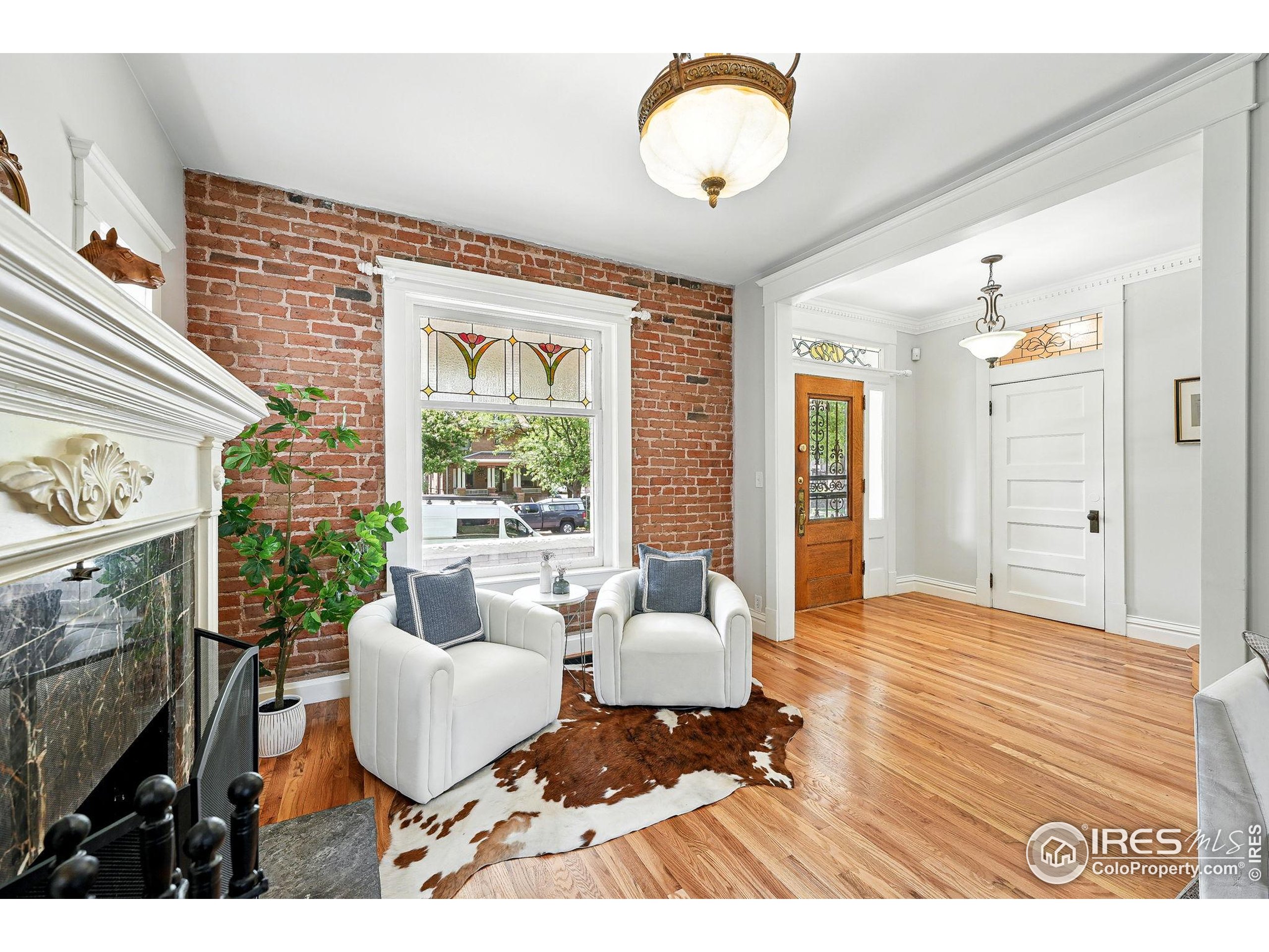 1582 Steele Street Denver, CO 80206 - Photo 7 of 48 a living room with furniture a fireplace and a large window
