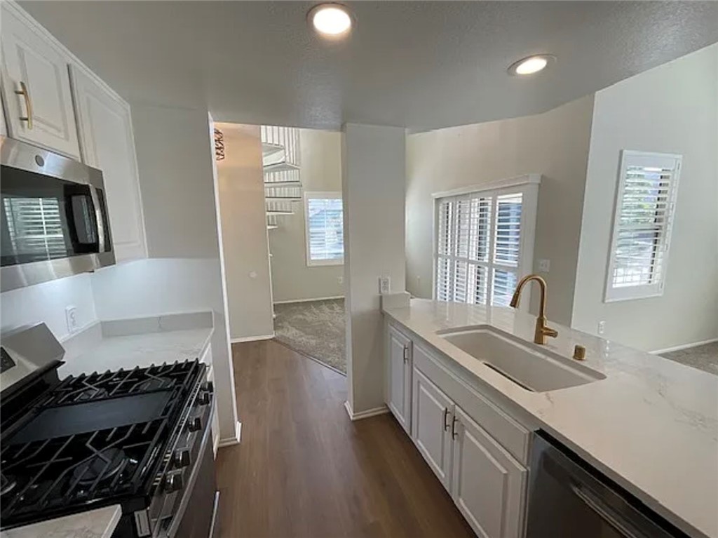 20000 Plum Canyon Road, Unit 225 Saugus, CA 91350 - Photo 5 of 12 a kitchen with granite countertop a stove and a sink