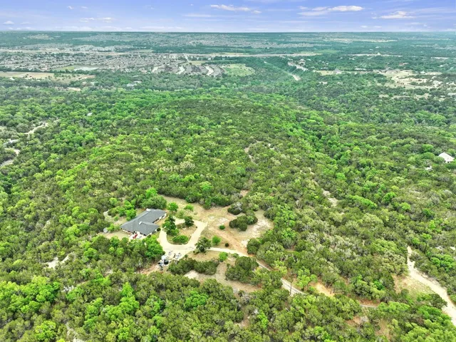 a view of a green field with lots of bushes