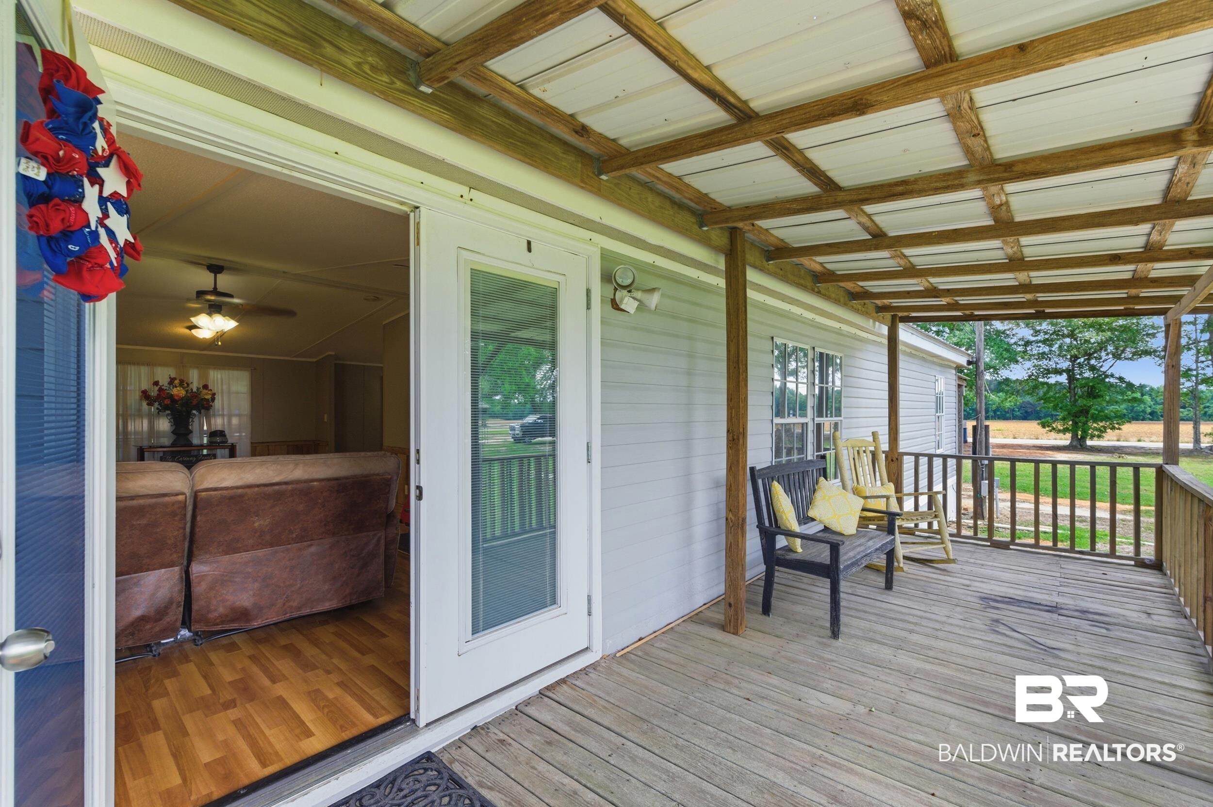 926 Tumbling Lane Atmore, AL 36502 - Photo 8 of 56 Expansive covered porch featuring wood decking, exposed wood beam ceiling, and white siding