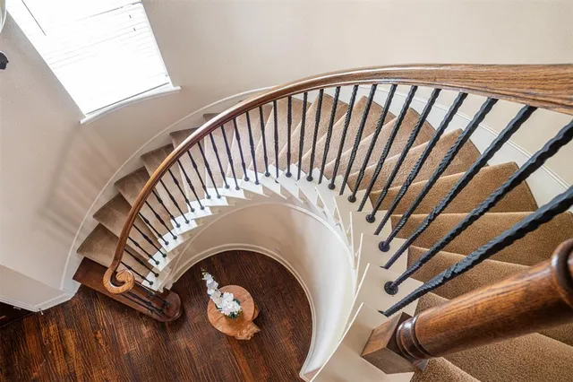 a living room with stainless steel appliances cabinets and a wooden floor
