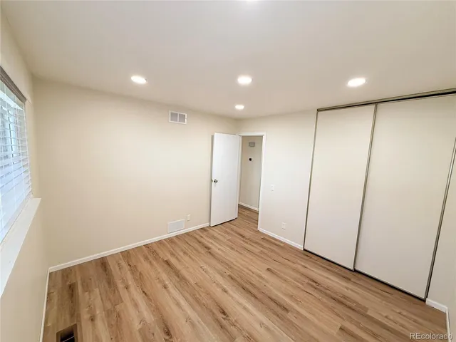 a view of hallway with a large window and wooden floor