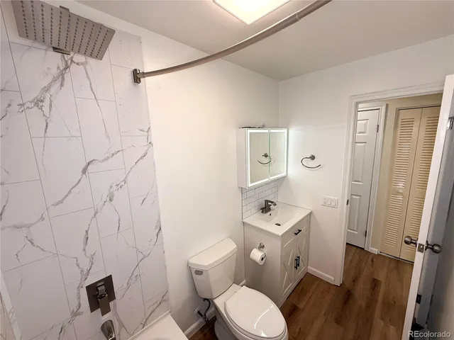 a white toilet sitting next to a bathroom sink and a shower