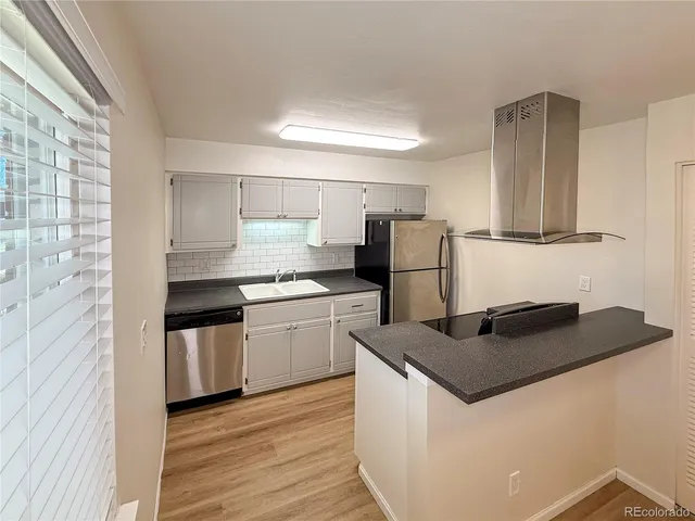 a kitchen with granite countertop a refrigerator stove top oven and sink