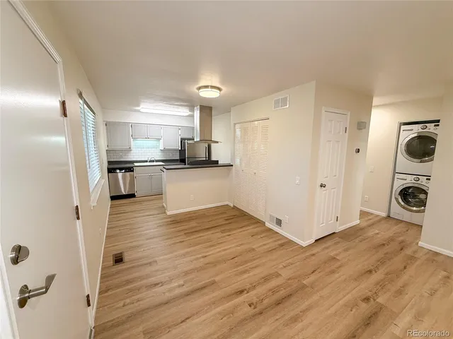 a view of a kitchen with wooden floor and electronic appliances