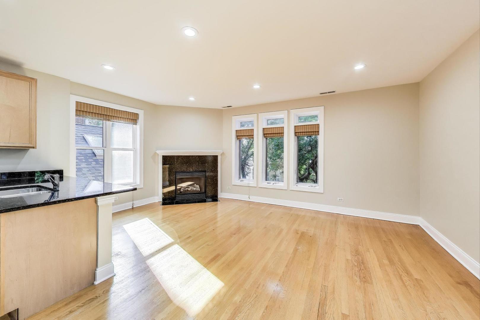 1308 West Fillmore Street, Unit 3 Chicago, IL 60607 - Photo 4 of 23 a view of a livingroom with wooden floor and a fireplace