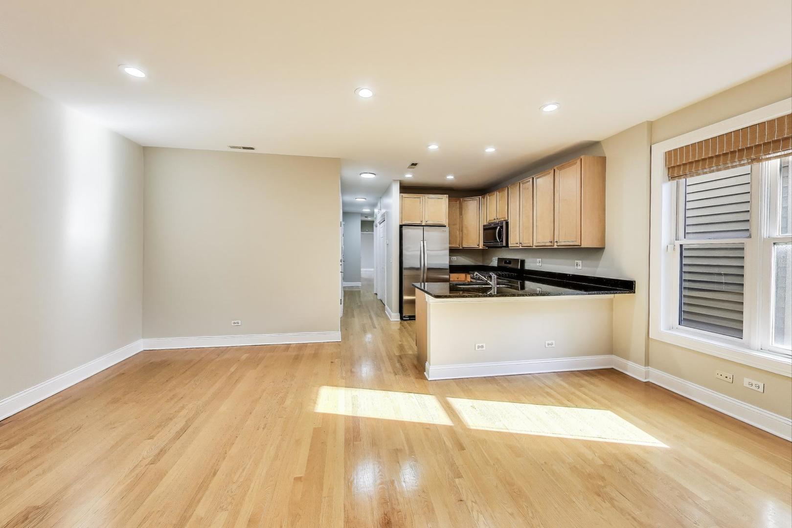 1308 West Fillmore Street, Unit 3 Chicago, IL 60607 - Photo 6 of 23 a view of kitchen with kitchen island a sink wooden floor and black white appliances