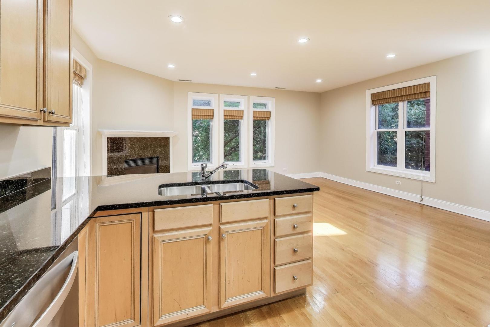 1308 West Fillmore Street, Unit 3 Chicago, IL 60607 - Photo 10 of 23 a kitchen with stainless steel appliances granite countertop a sink and cabinets with wooden floor