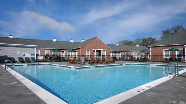 a view of a house with pool and chairs