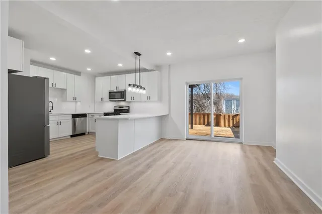 a view of kitchen with refrigerator stove and wooden floor