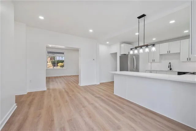 a view of an empty room and kitchen view