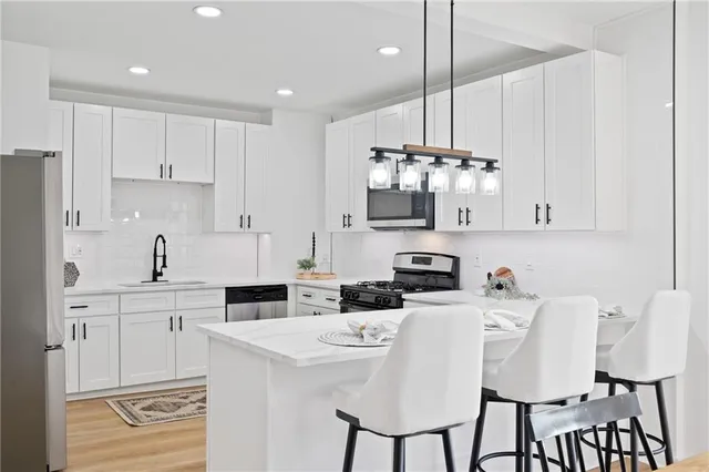 a kitchen with kitchen island granite countertop a sink cabinets and stainless steel appliances