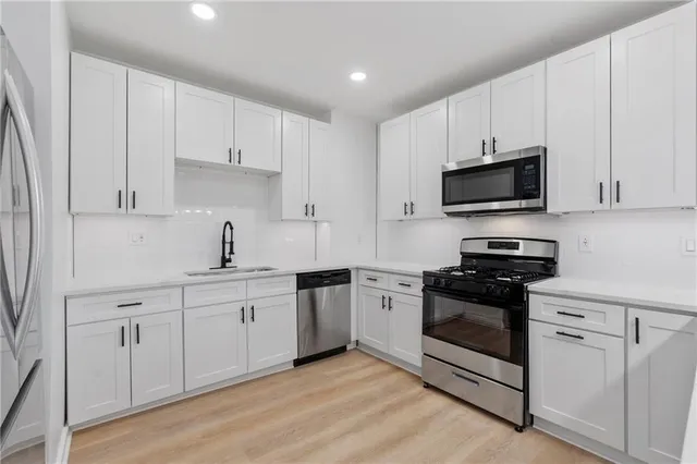 a kitchen with appliances a sink and cabinets