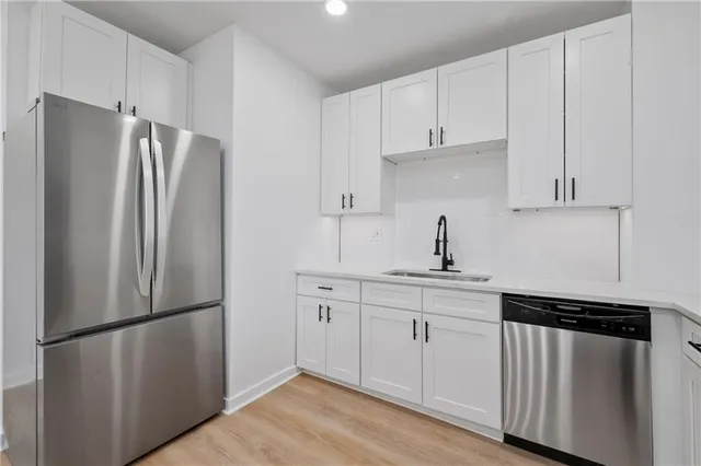 a kitchen with stainless steel appliances a refrigerator sink and cabinets