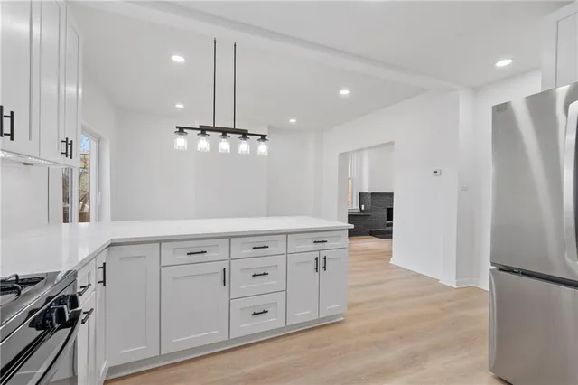 a kitchen with white cabinets and refrigerator