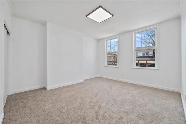 an empty room with windows and closet