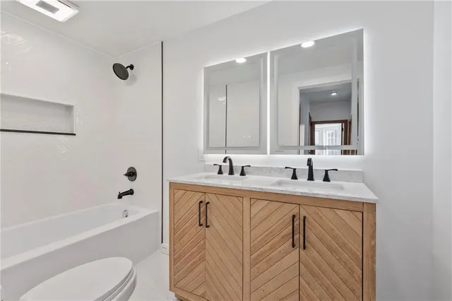 a bathroom with a granite countertop sink toilet and shower
