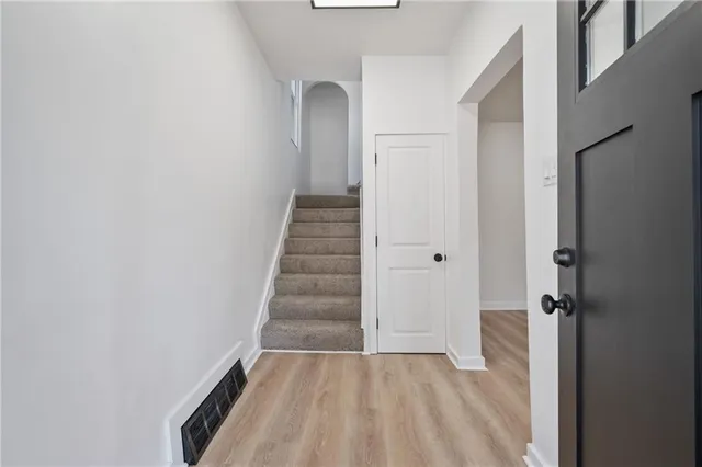 a view of a hallway with wooden floor and entryway