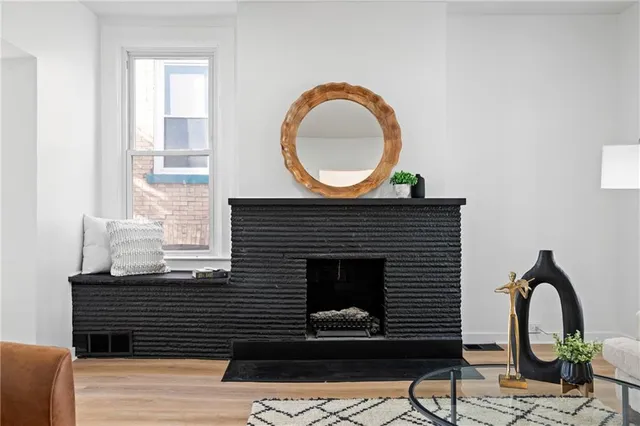 a living room with furniture a mirror and a fireplace