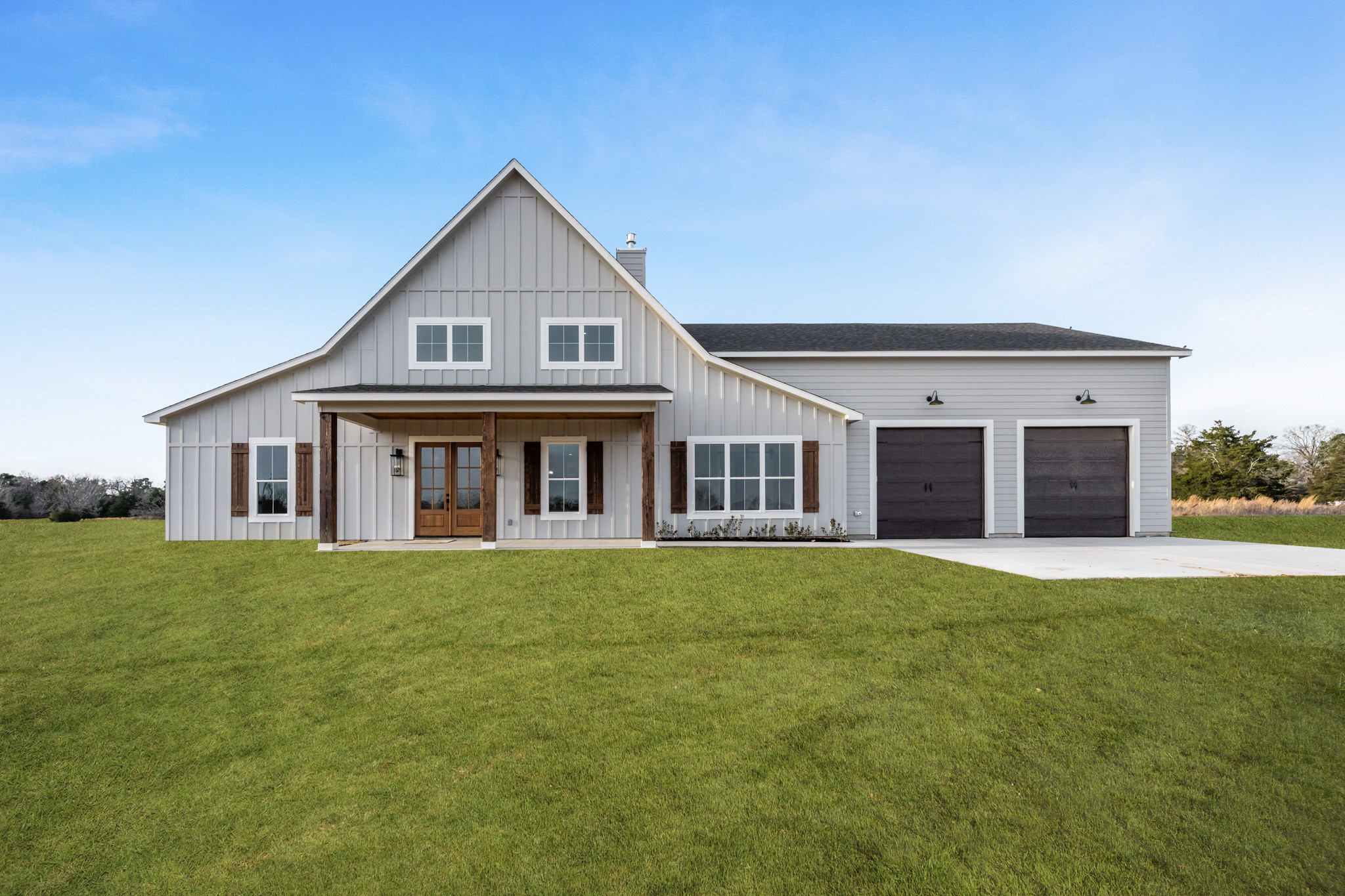 a front view of a house with a garden and trees