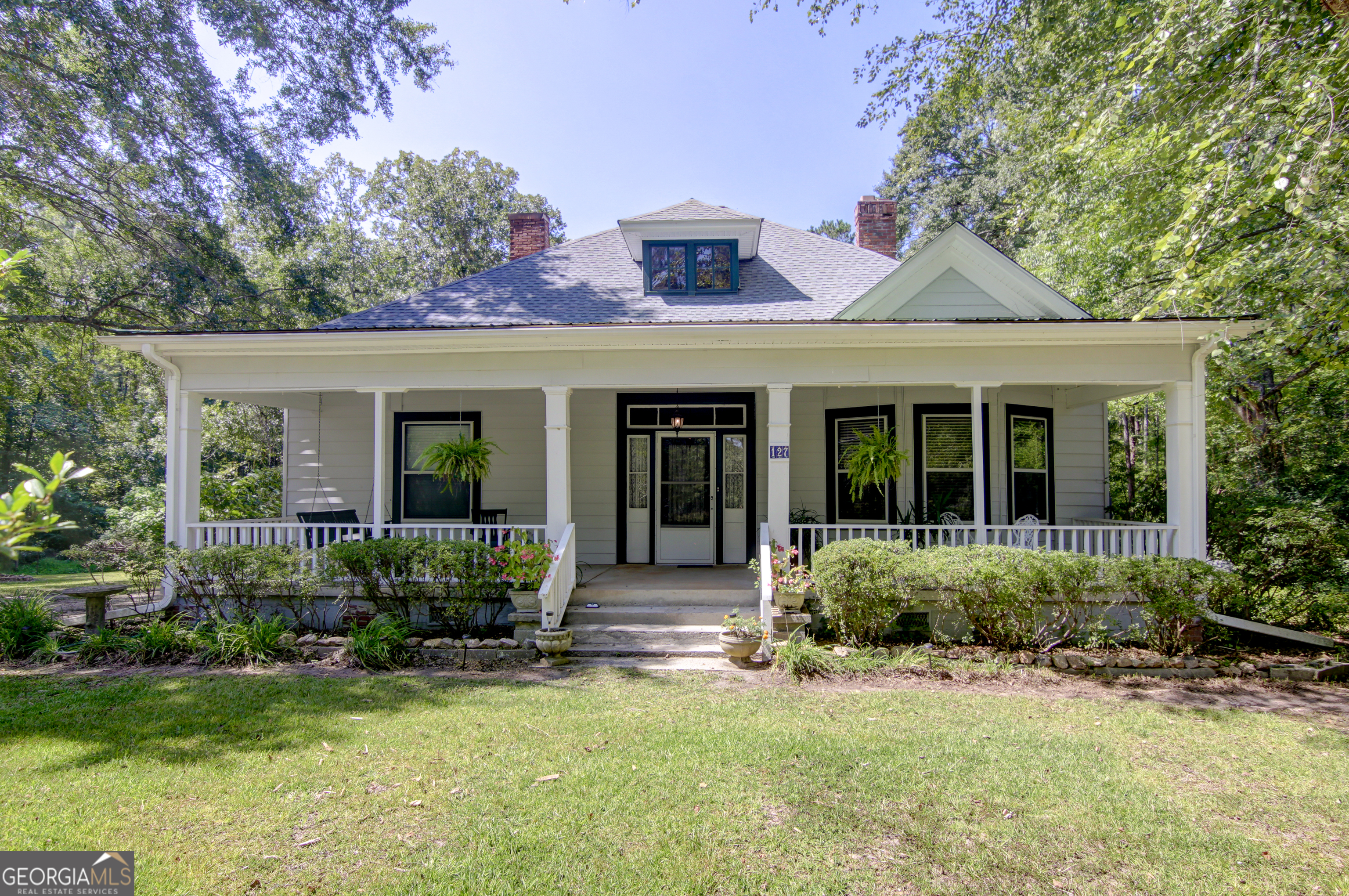a front view of a house with garden and porch