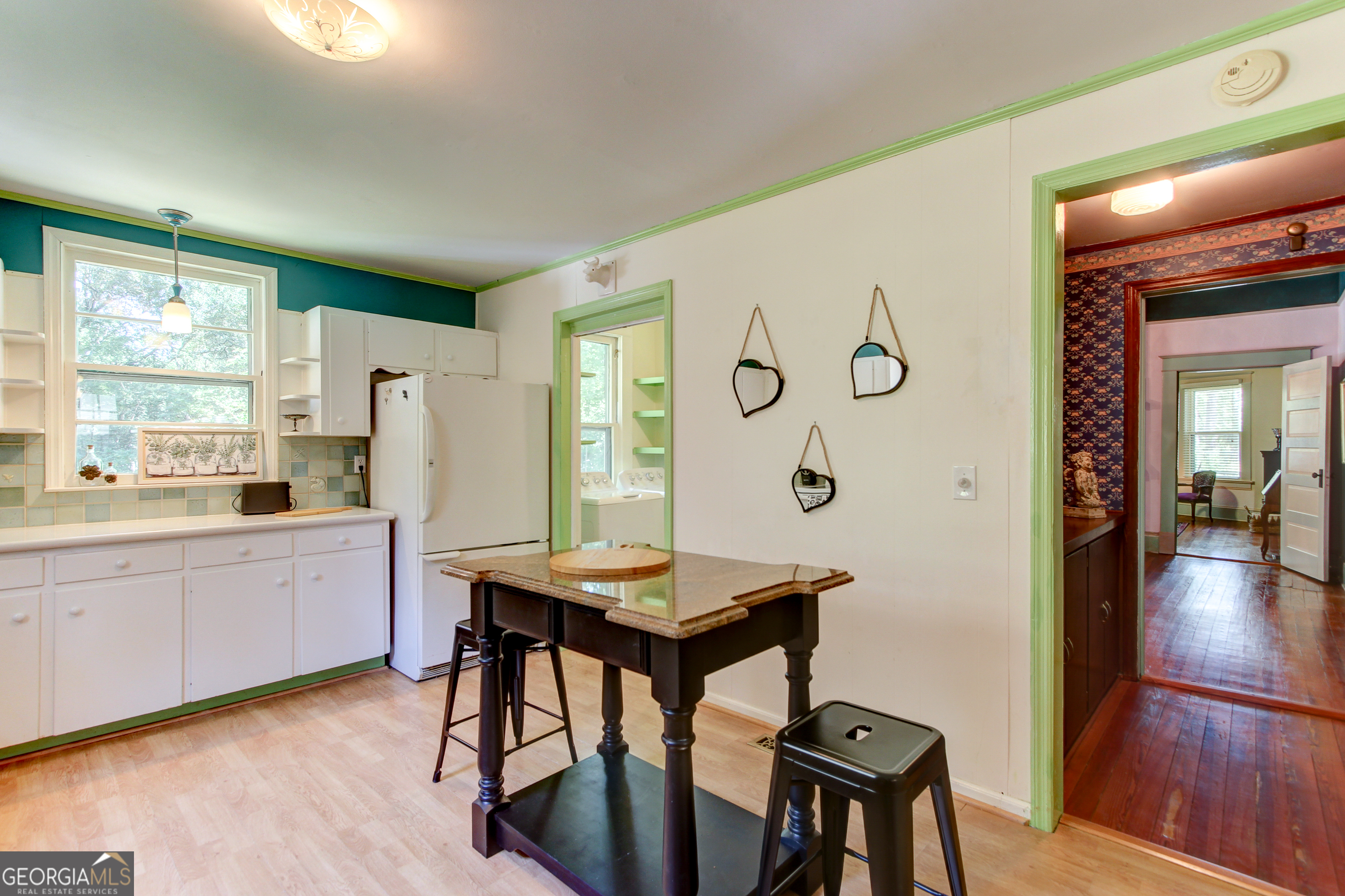 127 Wilkins Road Fayetteville, GA 30214 - Photo 45 of 53 a kitchen with stainless steel appliances granite countertop a stove a refrigerator a dining table and chairs with wooden floor