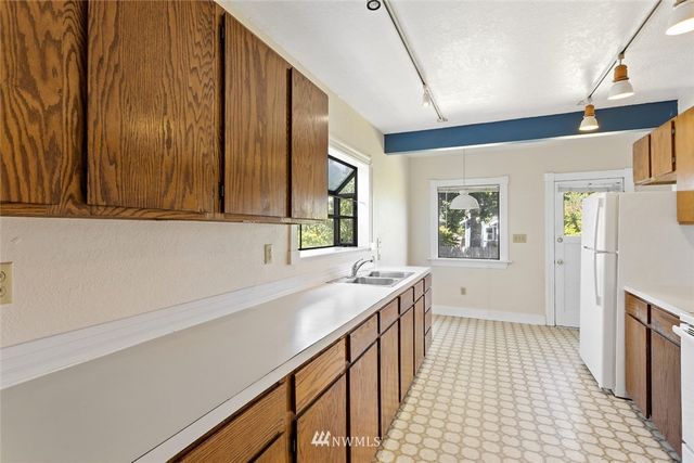 a kitchen with a sink a stove cabinets and wooden floor