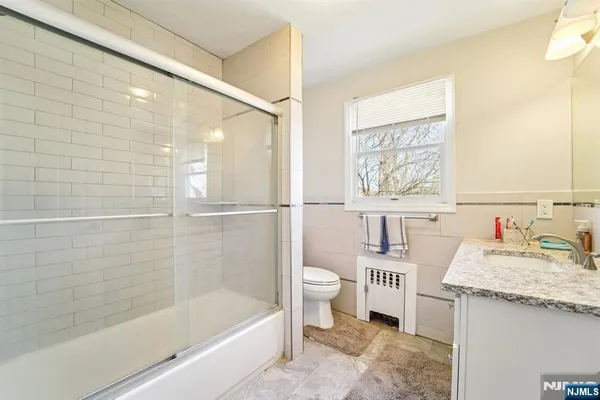 a bathroom with a granite countertop sink a toilet and bathtub