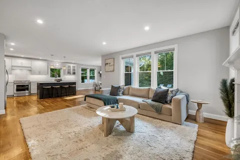 a living room with fireplace furniture and a large window