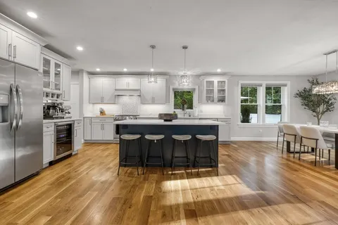 a kitchen with stainless steel appliances kitchen island granite countertop a refrigerator and a stove top oven