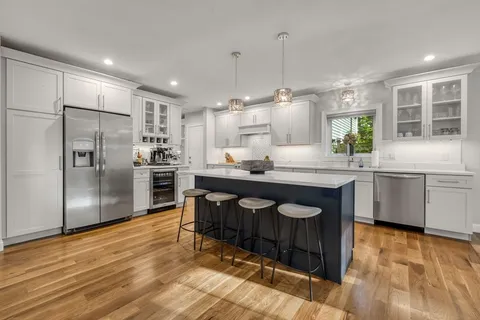 a kitchen with granite countertop a sink cabinets and stainless steel appliances