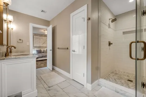 a bathroom with a granite countertop sink mirror and shower
