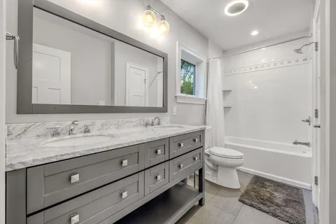 a bathroom with a granite countertop toilet a sink and a bathtub
