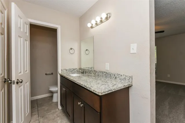 a bathroom with a granite countertop sink and a mirror