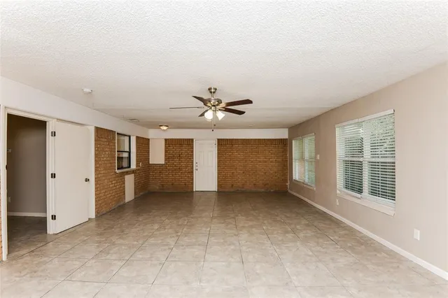 an empty room with windows and cabinet