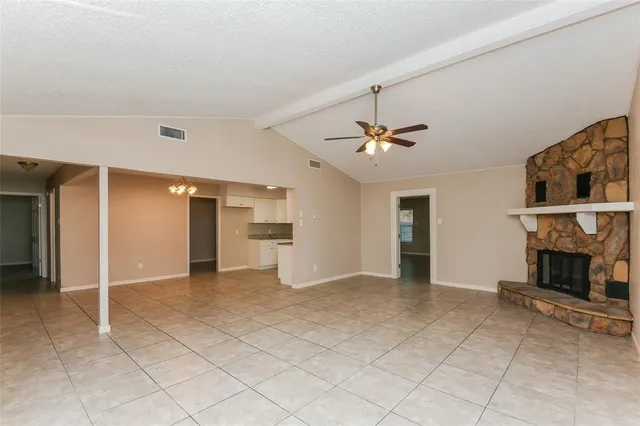an empty room with fireplace and fan
