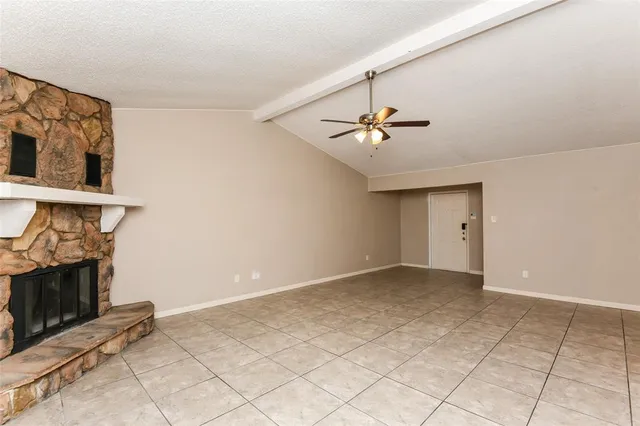 a view of an empty room with chandelier fan