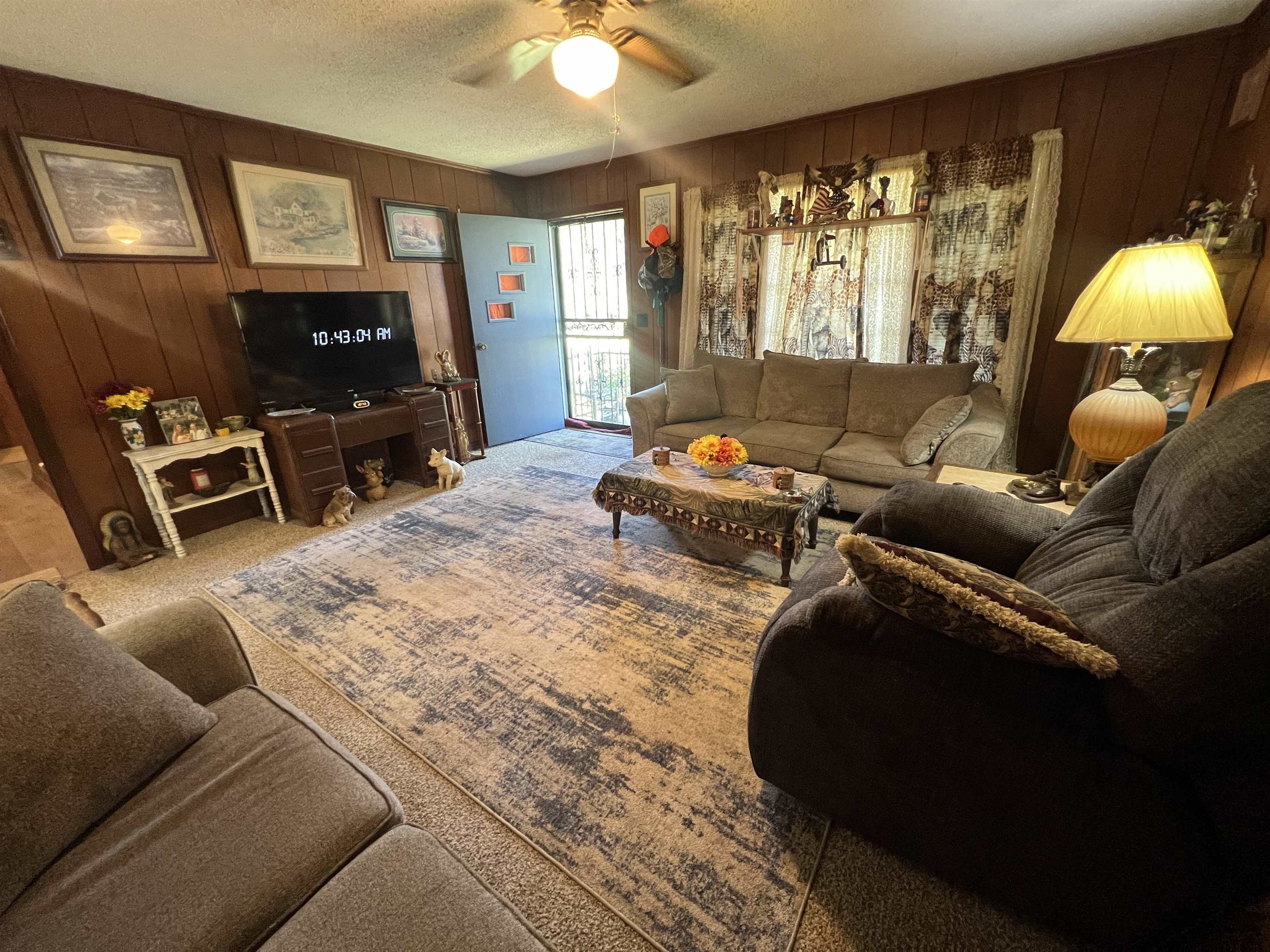 135 Angotti Road Crump, TN 38327 - Photo 8 of 29 Living room with wood walls, carpet, ceiling fan, and a textured ceiling