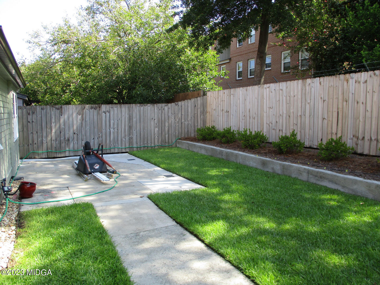 688 Monroe Street Macon, GA 31201 - Photo 12 of 26 a view of a backyard with a tree and wooden fence