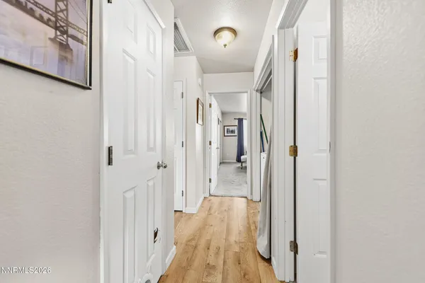 a view of a hallway with wooden floor and staircase