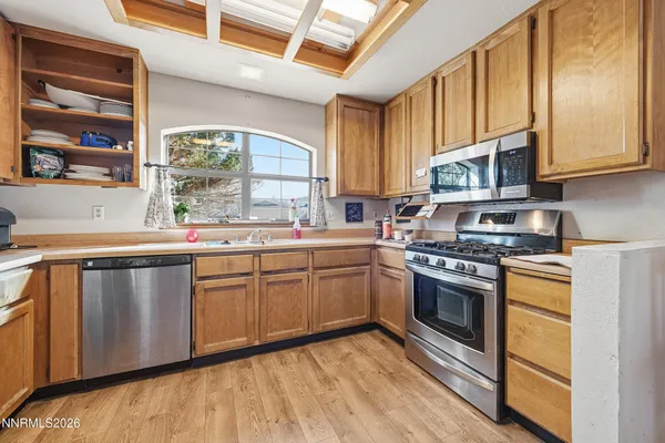 a kitchen with stainless steel appliances granite countertop a stove a sink and a microwave