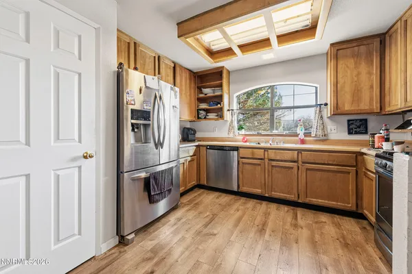 a kitchen with a sink cabinets stainless steel appliances and a window