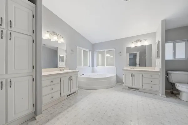 an empty room with windows and ceiling fan