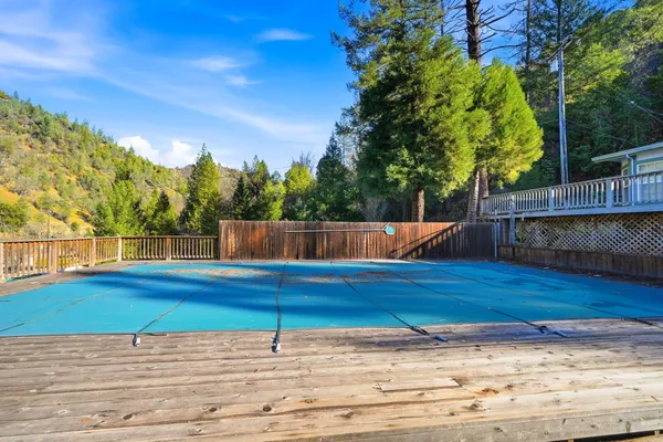 a view of a backyard with table and chairs and wooden fence