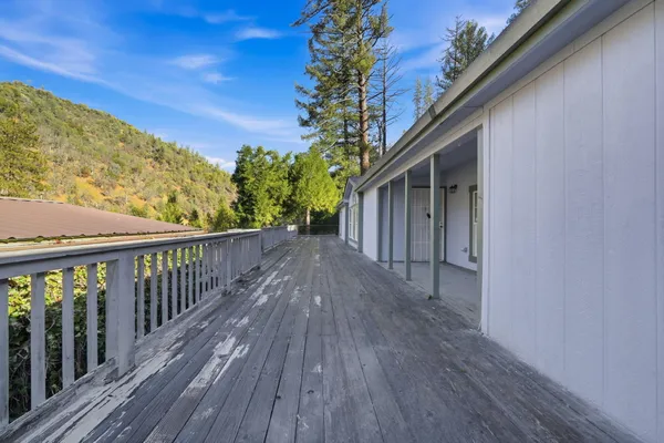 an empty room with wooden floor windows and a ceiling fan